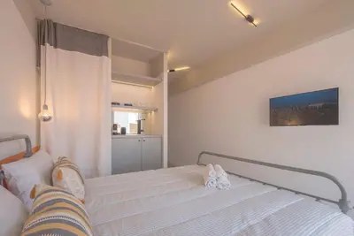 a small bedroom with a bed with a curtain at Charming apartment on Athens most famous street in Athens