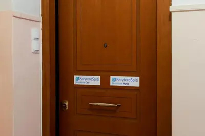a wooden door with two signs on it at Best House Cleo Pasalimani Piraeus in Piraeus
