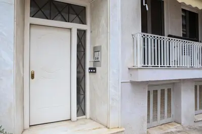a white door on a building with a balcony at Best House Cleo Pasalimani Piraeus in Piraeus