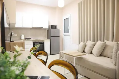 a living room with a couch and a kitchen at Best House Electra Pasalimani Piraeus in Piraeus