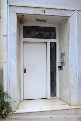 a white door in a white building with at Best House Electra Pasalimani Piraeus in Piraeus