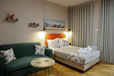 a bedroom with a bed and a couch and a table at Best House Myrto Pasalimani Piraeus in Piraeus
