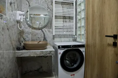 a bathroom with a washing machine and a mirror at Best House Myrto Pasalimani Piraeus in Piraeus