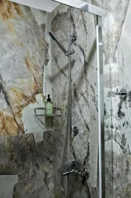 a shower in a bathroom with a stone wall at Best House Myrto Pasalimani Piraeus in Piraeus