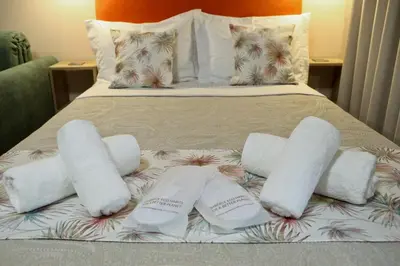 a bed with four rolled up towels on it at Best House Myrto Pasalimani Piraeus in Piraeus
