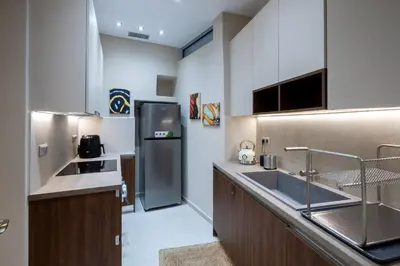 a kitchen with a sink and a refrigerator at Acropolis slow living apt - Ground floor in Athens