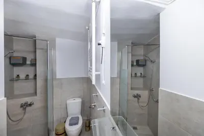 a bathroom with a shower and a toilet and a tub at Acropolis slow living apt - Ground floor in Athens
