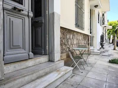 a table and chairs sitting outside of a building at Acropolis slow living apt - Ground floor in Athens