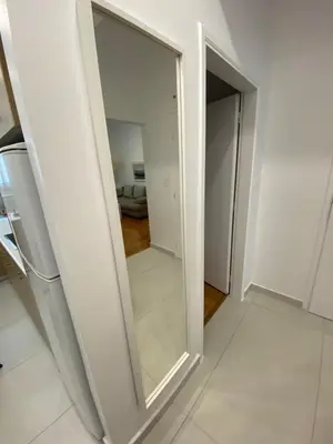 a mirror in a white room with a hallway at Neapoli Modern Apartment in Athens