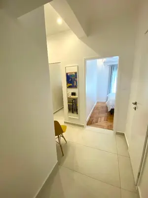 a white room with a mirror and a chair at Neapoli Modern Apartment in Athens