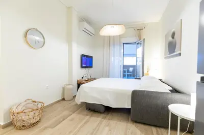 a white bedroom with a bed and a couch at Eliá Designer Suite - Terraza Lycabettus y Lujo en Mesogeion in Athens