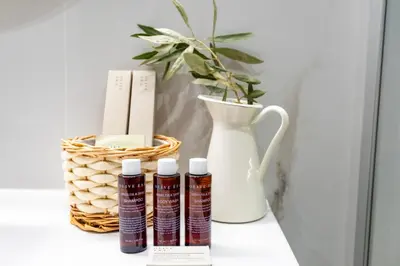 a vase and three bottles of essential oils on a shelf at Eliá Designer Suite - Terraza Lycabettus y Lujo en Mesogeion in Athens