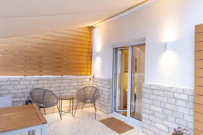 a patio with two chairs and a table at Eliá Designer Suite - Terraza Lycabettus y Lujo en Mesogeion in Athens