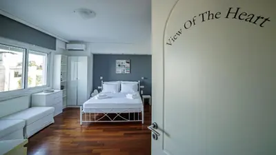 a bedroom with a white bed and a window at Seaside Grey Pearl Villa in Piraeus
