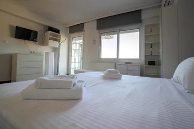 a large white bed with towels on top of it at Seaside Grey Pearl Villa in Piraeus