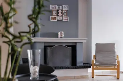 a living room with a fireplace and a chair at Seaside Grey Pearl Villa in Piraeus