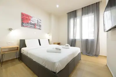 a bedroom with a large bed and a window at Chic 1-Bedroom Apartment with balcony by WeHost Athens in Athens