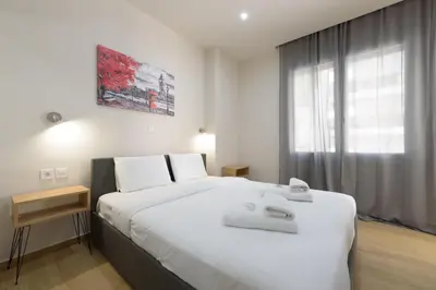 a bedroom with a large white bed and a window at Chic 1-Bedroom Apartment with balcony by WeHost Athens in Athens