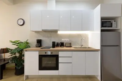 a kitchen with white cabinets and a sink at Chic 1-Bedroom Apartment with balcony by WeHost Athens in Athens