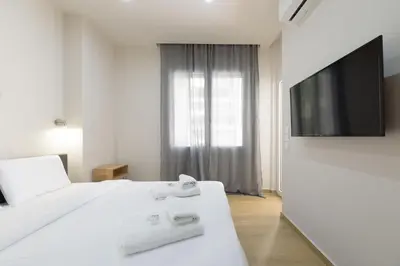 a bedroom with two white beds and a flat screen tv at Chic 1-Bedroom Apartment with balcony by WeHost Athens in Athens