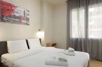 a bedroom with a large white bed with towels on it at Chic 1-Bedroom Apartment with balcony by WeHost Athens in Athens
