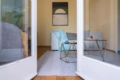 a living room with a table and a chair at Whispering Walls Premium 1 bedroom Apartment in Athens