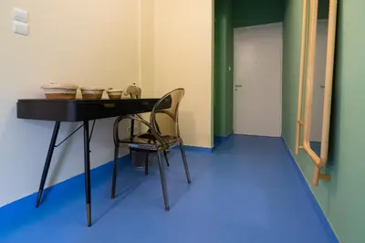 a room with a table and a chair and a door at Whispering Walls Premium 1 bedroom Apartment in Athens