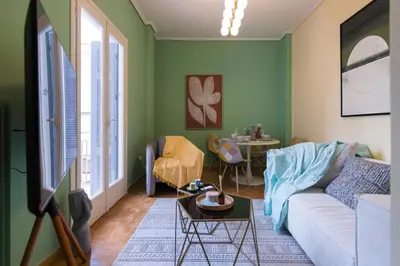 a living room with green walls and a white couch at Whispering Walls Premium 1 bedroom Apartment in Athens