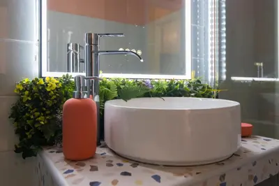 a bathroom with a tub and a sink and flowers at Whispering Walls Premium 1 bedroom Apartment in Athens