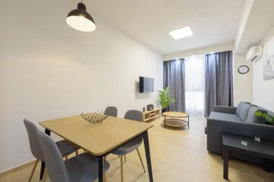 a living room with a table and a couch at Bright 1-Bedroom Apartment by WeHost Athens in Athens