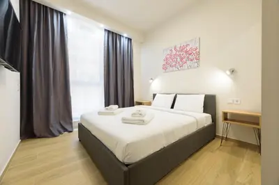 a bedroom with a large bed with two towels on it at Bright 1-Bedroom Apartment by WeHost Athens in Athens