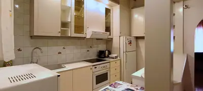 a kitchen with white cabinets and a sink and a refrigerator at Down Town Flat Apartment in Athens