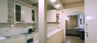 a kitchen with white cabinets and a living room at Down Town Flat Apartment in Athens