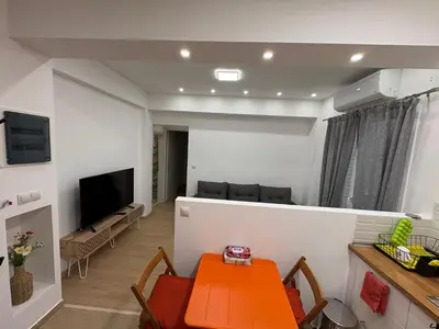 a living room with a table and a television at AtticHub in Athens