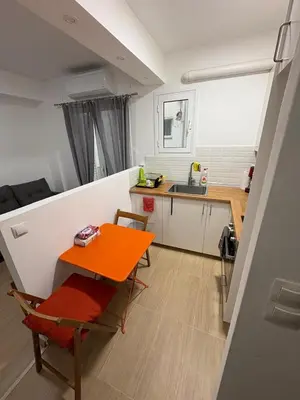 a small kitchen with a orange table and a sink at AtticHub in Athens