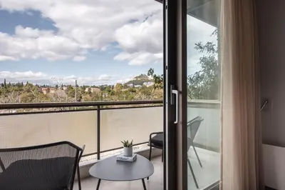 a room with a balcony with a table and chairs at Chic Urban Suite - Parthenon Viewpoint in Athens