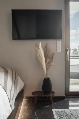 a black vase with feathers on a table in a bedroom at Chic Urban Suite - Parthenon Viewpoint in Athens