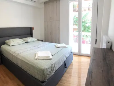 a bedroom with a bed with two towels on it at 3 BD apart in the center of Athens 2min from metro in Athens