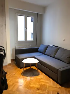 a living room with a blue couch and a table at 3 BD apart in the center of Athens 2min from metro in Athens