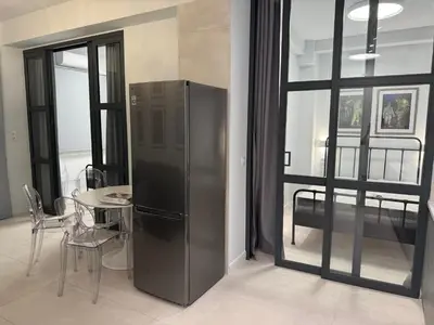 a kitchen with a stainless steel refrigerator and a table at AMG Superior Central Apartment sleeps up to 5 in Athens