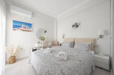 a white bedroom with a bed with towels on it at Quiet Escape Near Acropolis in Athens