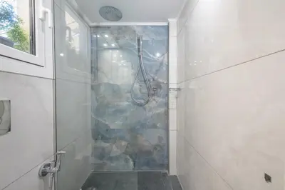 a shower with a glass door in a bathroom at Quiet Escape Near Acropolis in Athens