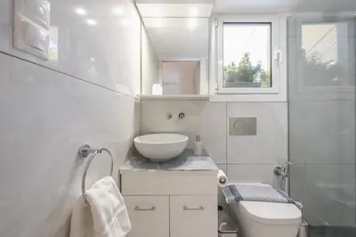 a white bathroom with a sink and a toilet at Quiet Escape Near Acropolis in Athens