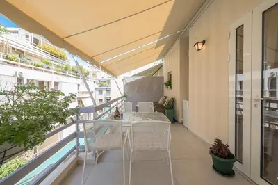 a balcony with a table and chairs on a building at Quiet Escape Near Acropolis in Athens