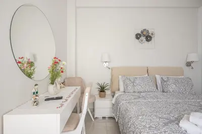 a bedroom with a bed and a mirror and a table at Quiet Escape Near Acropolis in Athens