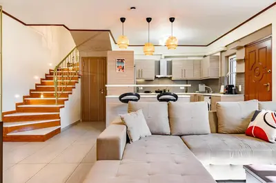 a living room with a couch and a kitchen at Lovehome - 4BD Villa with views-15mins to airport,10mins to MEC ΑΕ- 2mins to bus stop ,10mins to Suburban Railway on foot in Athens