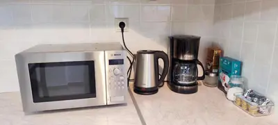 a microwave sitting on a counter next to a coffee maker at Zen Apartment in Athens