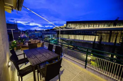 a table and chairs on the balcony of a building at Acropolis Touch 7th Wonder View DG in Athens