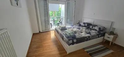 a bedroom with a bed and a balcony with a table at Jasmine House in Athens
