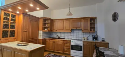 a kitchen with wooden cabinets and a white stove top oven at Jasmine House in Athens